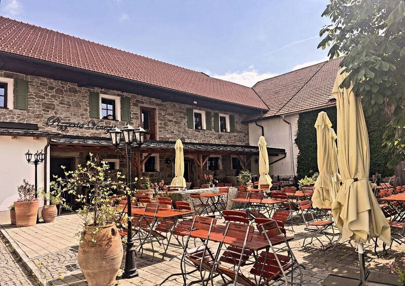 Innenhof mit Sonnenschirmen, Tischen und Kübelpflanzen