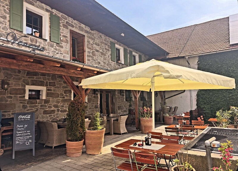 Innenhof der Pizzeria Venezia mit gelbem Sonnenschirm