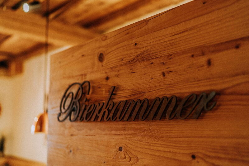 Holzschild „Bierkammer“ an der Holzwand