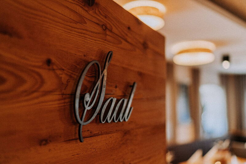 Holzschild „Saal“ an der Holzwand