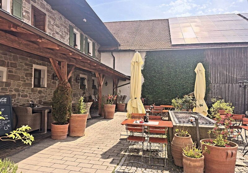 Innenhof mit Sonnenschirmen vor der Natursteinfassade