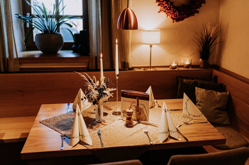 Gedeckter Tisch mit Kerzen in einer gemütlichen Ecke der Gaststube